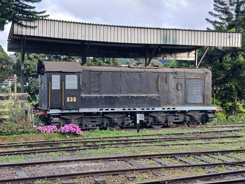 A black Class G2 diesel shunter numbered 535 under a corrugated shelter beside the tracks at Bandarawela station