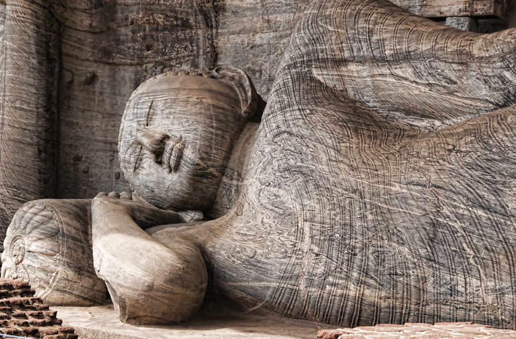 The head and shoulders of the reclining Buddha at Gal Vihara, carved from granite with the folds of the robe visible