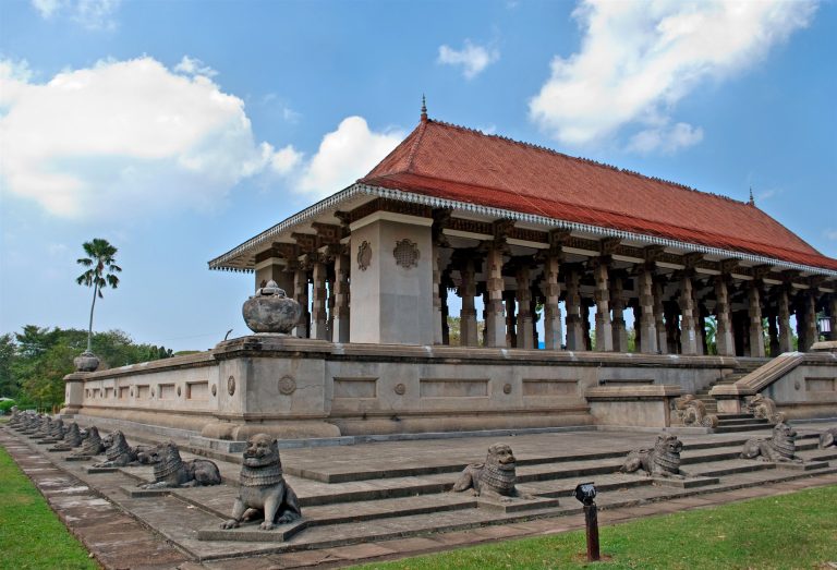 The red-roofed Independence Memorial Hall in Colombo, open-sided with rows of columns and stone lions on the steps