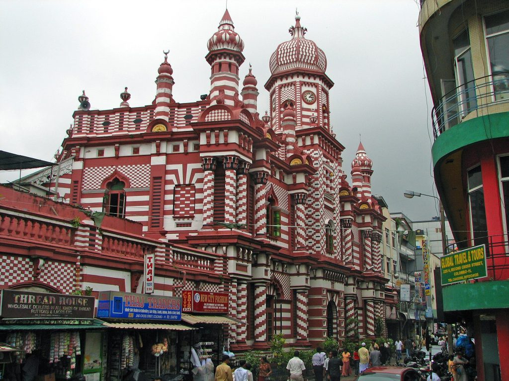 The red-and-white striped Jami Ul-Alfar Mosque seen from Second Cross Street in Pettah, with its domed clock tower, minarets and shopfronts below
